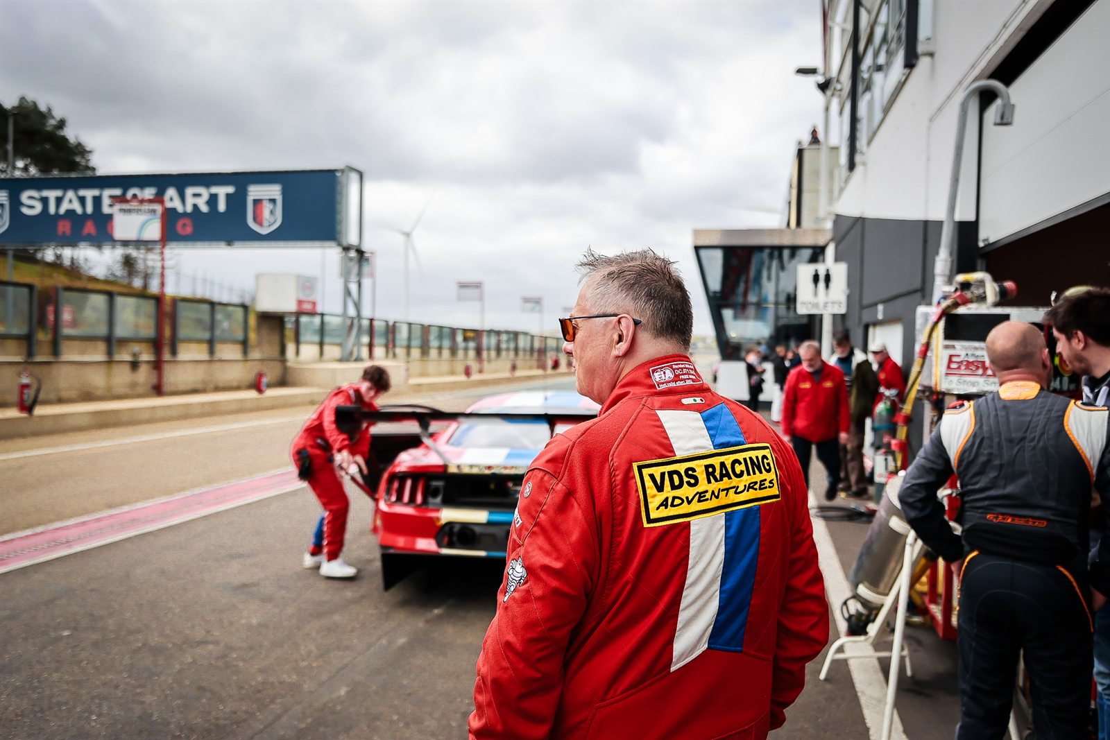 Paddock de Zolder, mecaniciens au travail et moments entre equipiers